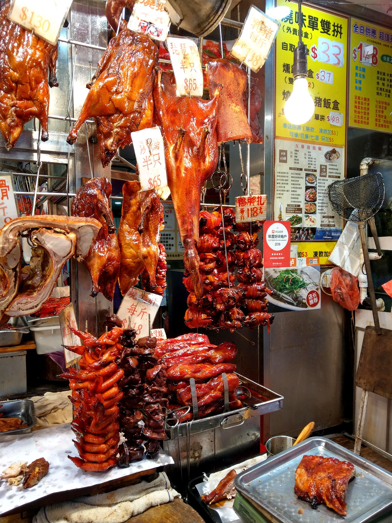 A Hong Kong siu mei window — glossy char siu and roast meats hanging by the slab