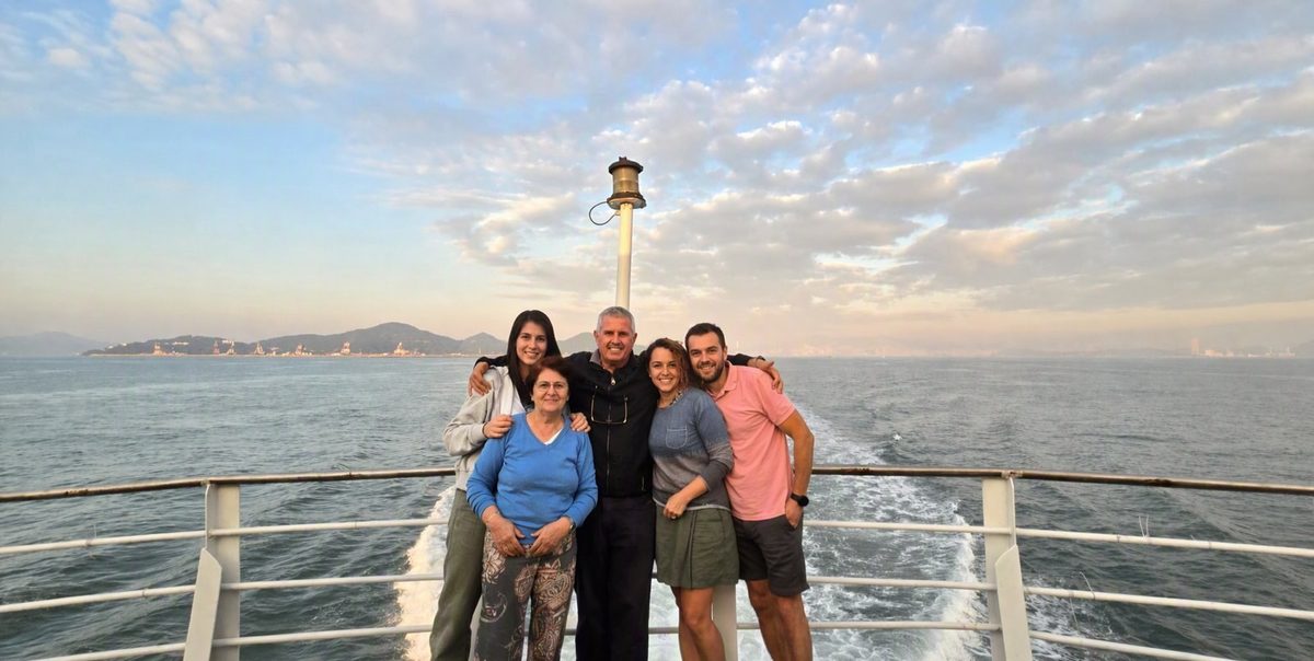 Hans with guests on a ferry at sunset